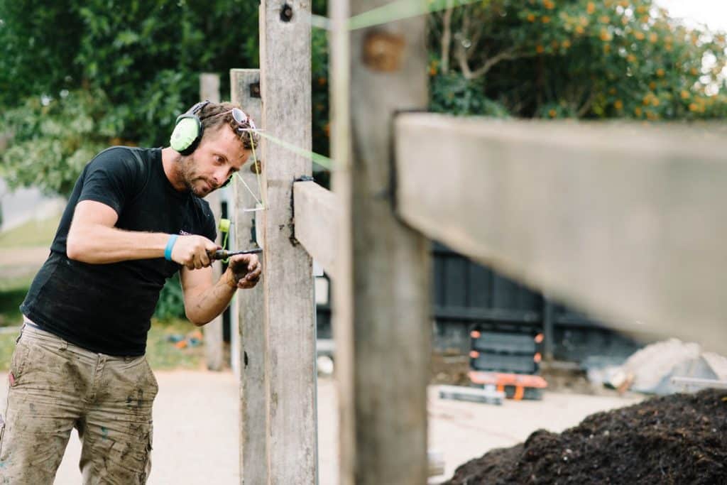 a professional landscaper using tools to build a custom front fence in melbourne