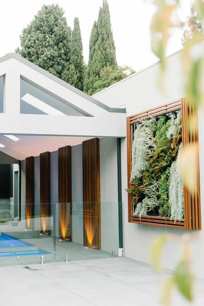 a living green wall next to a custom in ground concrete pool