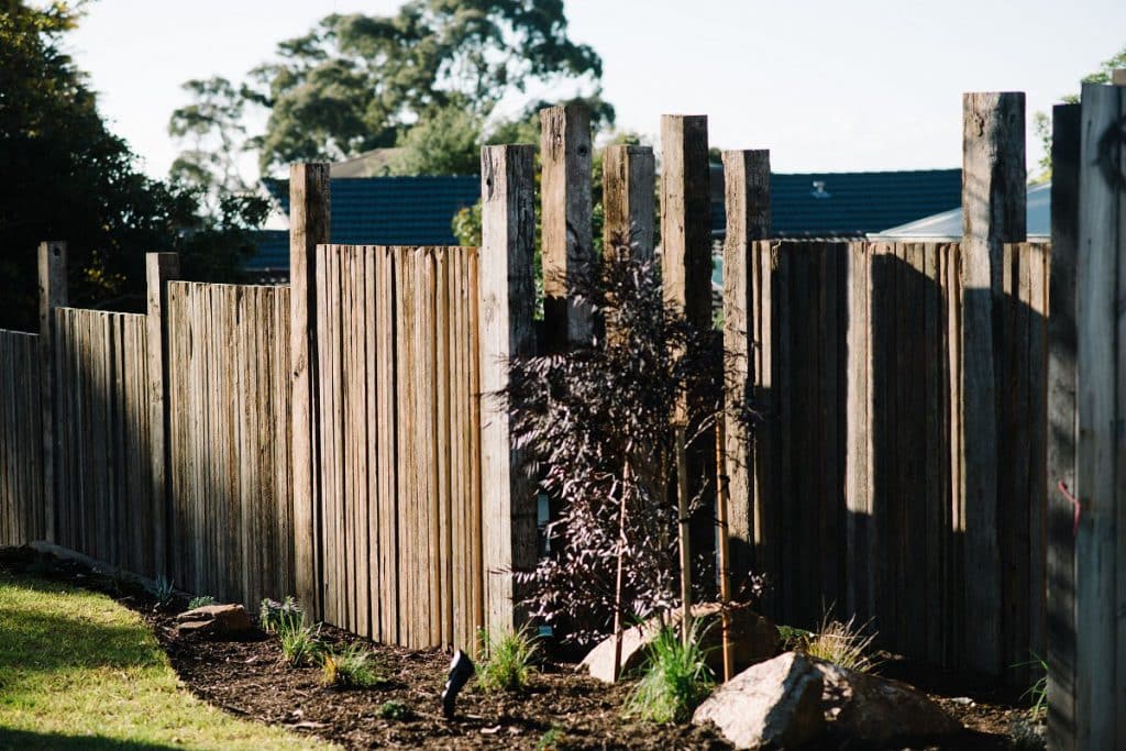 a custom vertical wooden fence encasing a small native garden